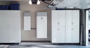 A garage with two white cabinets and one is open.